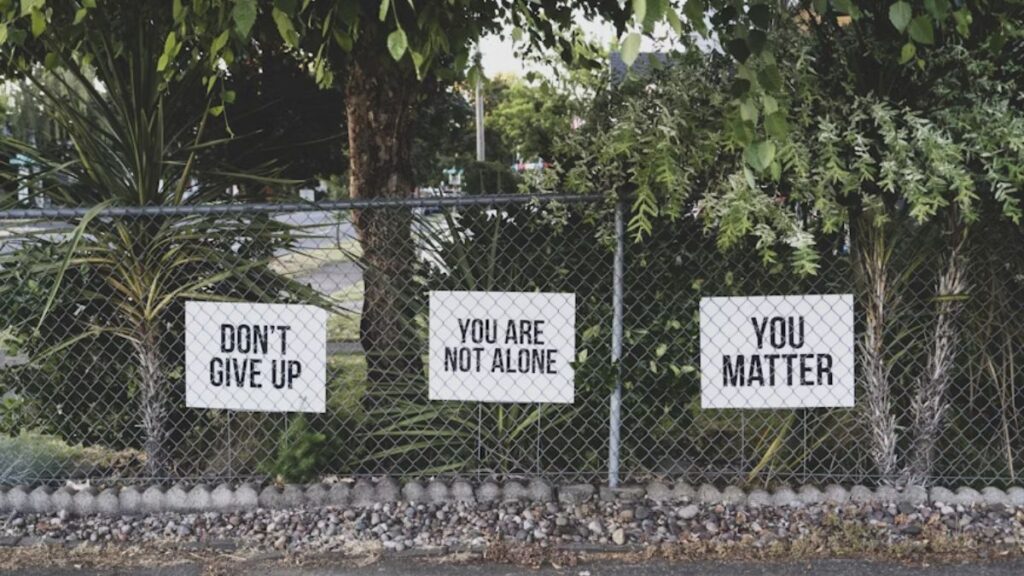 What to Expect During Your First Alcohol Detox at a Rehab Center in Chicago 3 Signs behind chicken wire read “You Are Not Alone” in black block letters on a plain white background.