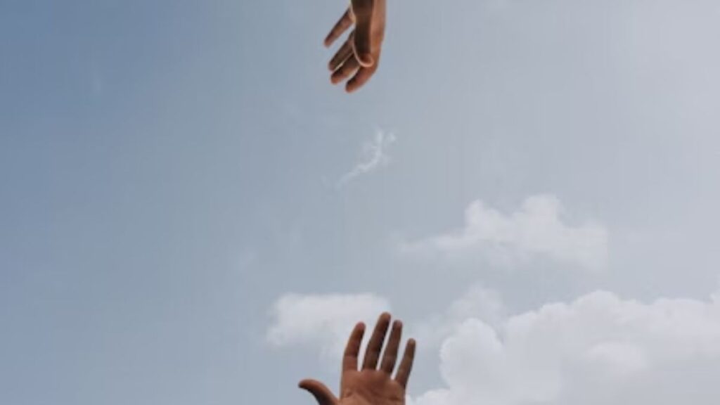 Exploring Chicago’s Holistic Therapy Options for Addiction Recovery 4 Two hands reaching out toward each other against a clear blue sky.