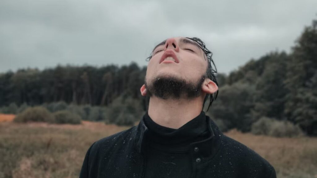 What to Expect During Alcohol Detox: A Step-by-Step Guide 2 Man in pain looking upward in a wide open space beneath a vast sky.