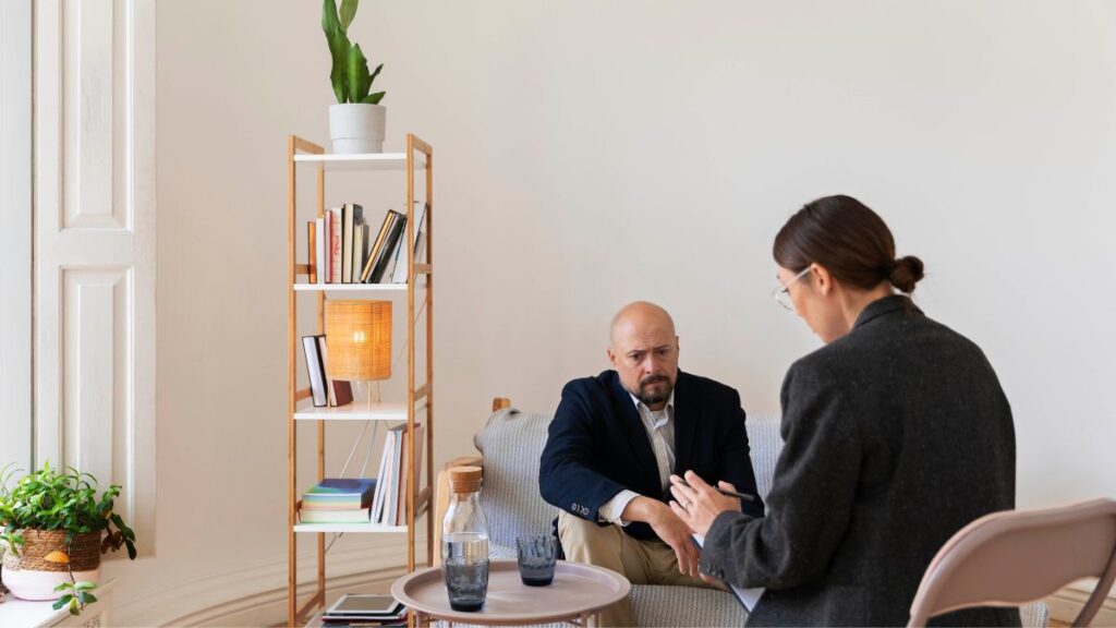 How Professionals Can Overcome Addiction While Maintaining Their Careers 4 A worried employee receives therapy and counseling from human resources, seeking support during addiction recovery.